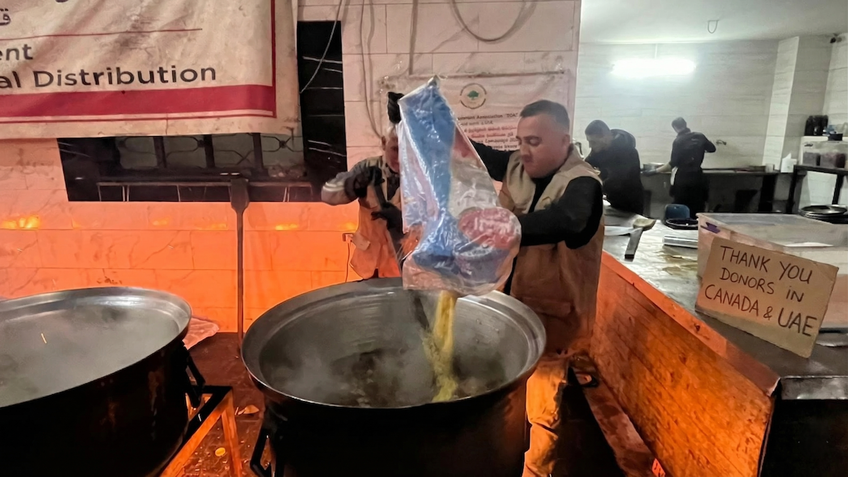 Rice being cooked with donor thank-you sign
